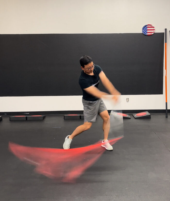 A man demonstrating the Mach 3 Iron Whip golf speed training tool.