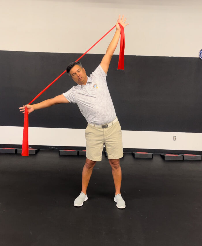 A man demonstrating the Mach 3 Iron Whip golf speed training tool.