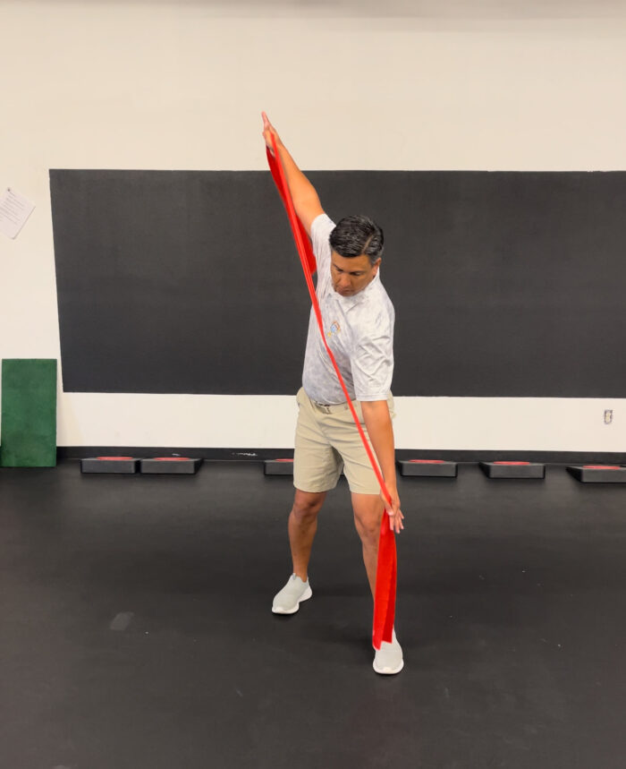 A man demonstrating the Mach 3 Iron Whip golf speed training tool.